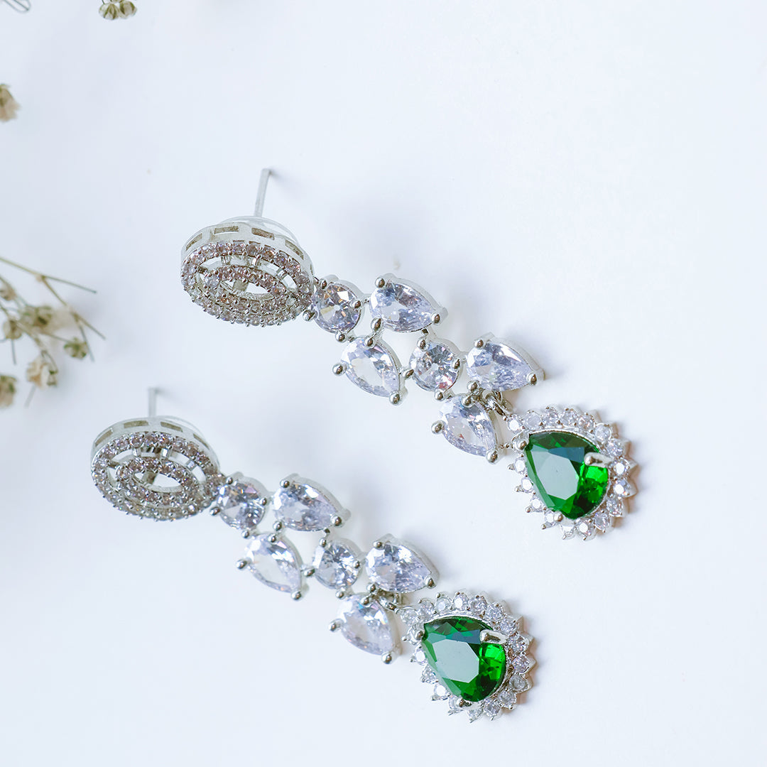 Pair of earrings with green gemstones on a white background