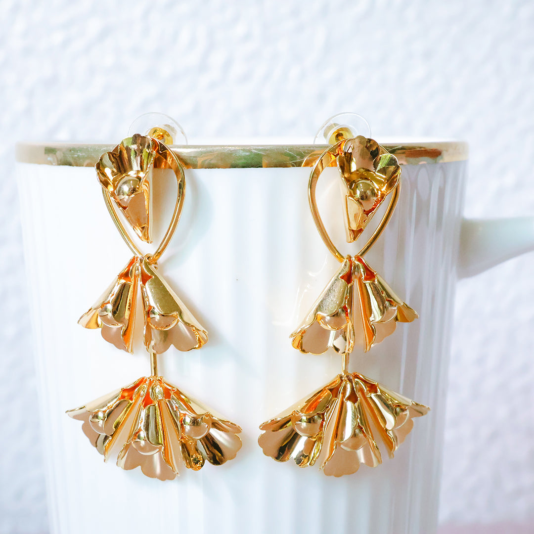Gold floral earrings on a white background