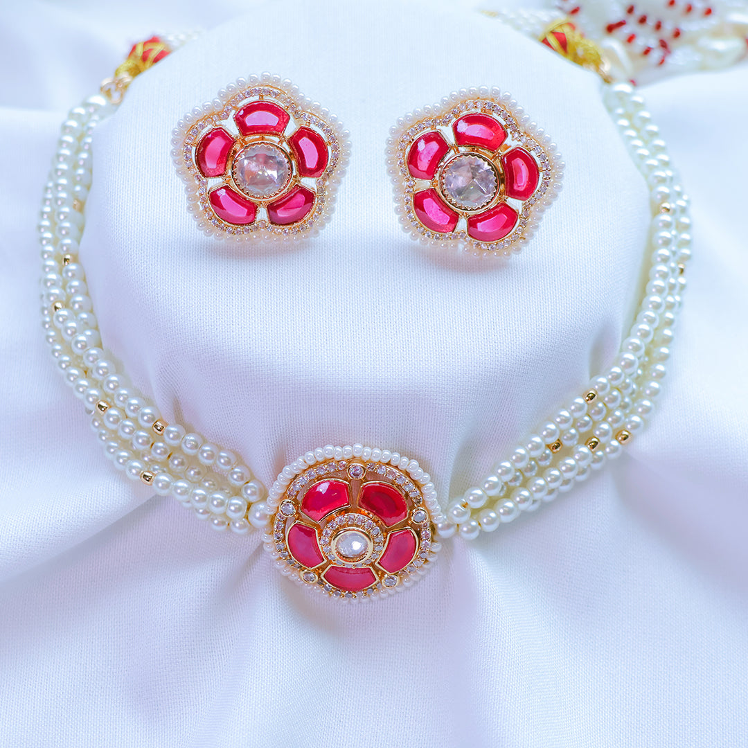Pearl necklace with red floral pendants on a white background