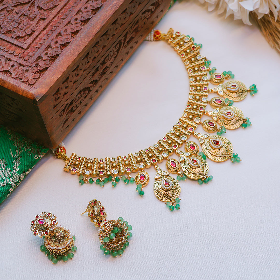 Gold jewelry set with tiara, necklace, and earrings on a white background