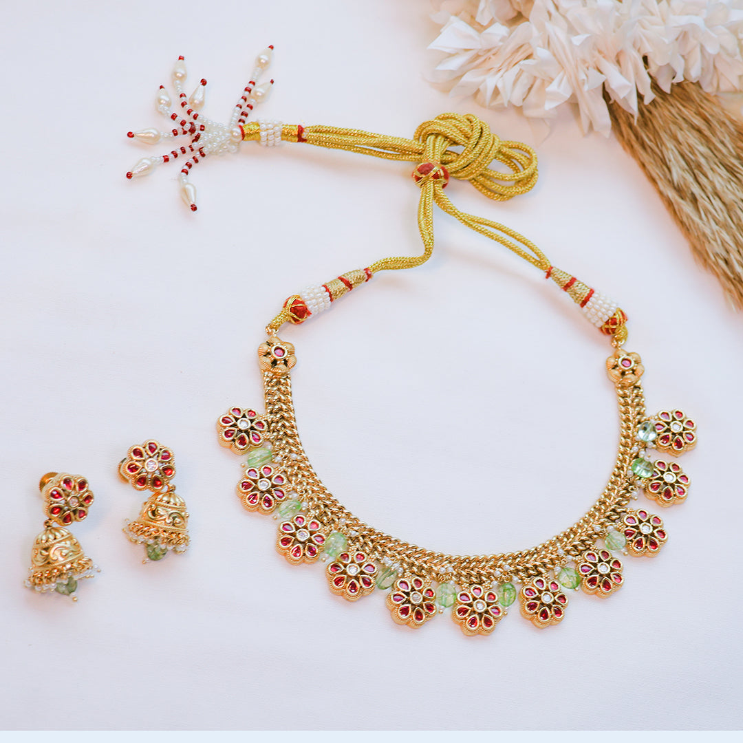 Gold necklace and earrings set on a white background