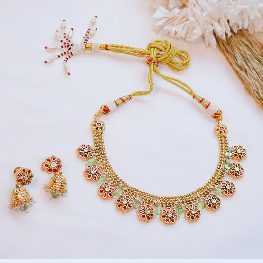 Gold necklace and earrings set on a white background