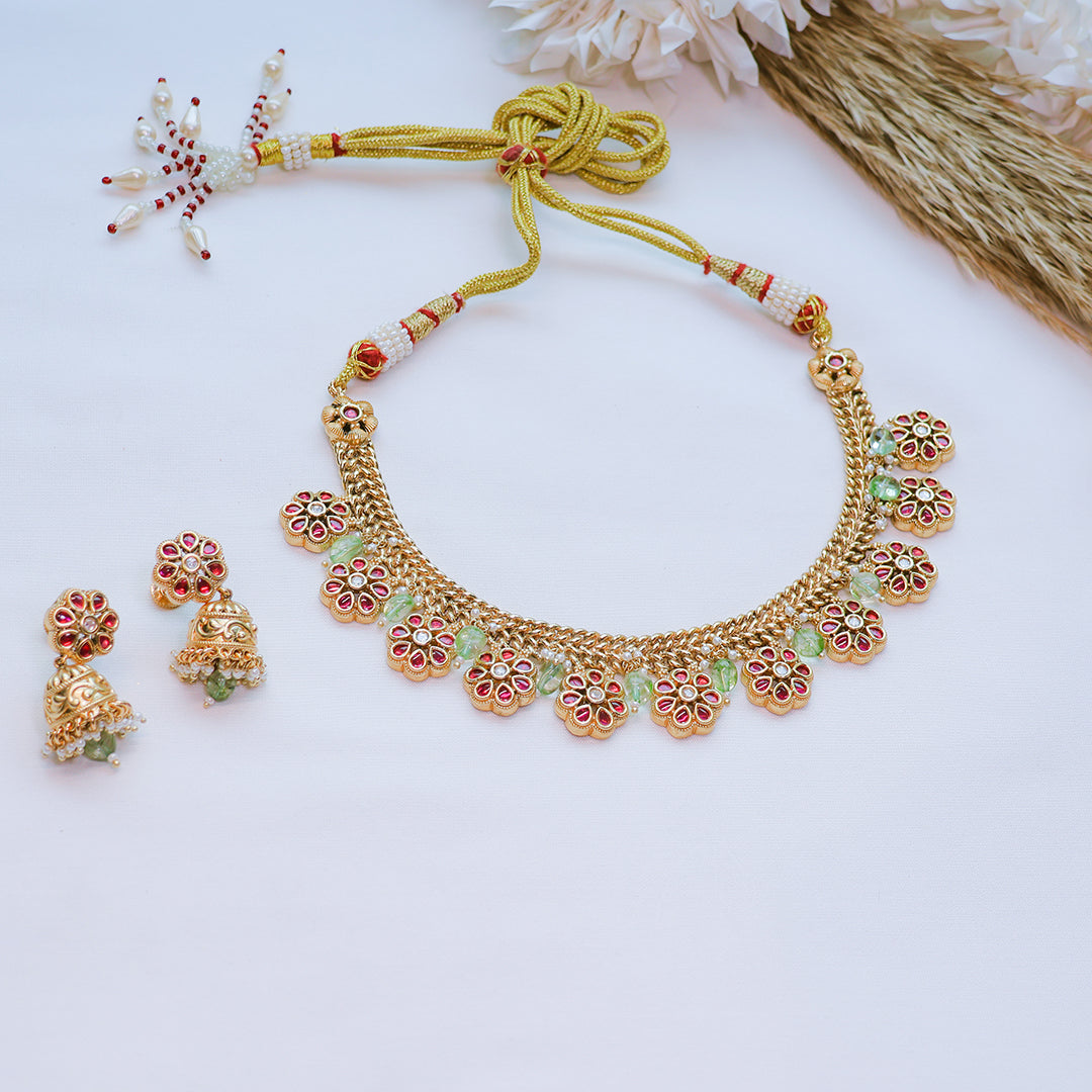 Gold necklace and earrings set on a white background