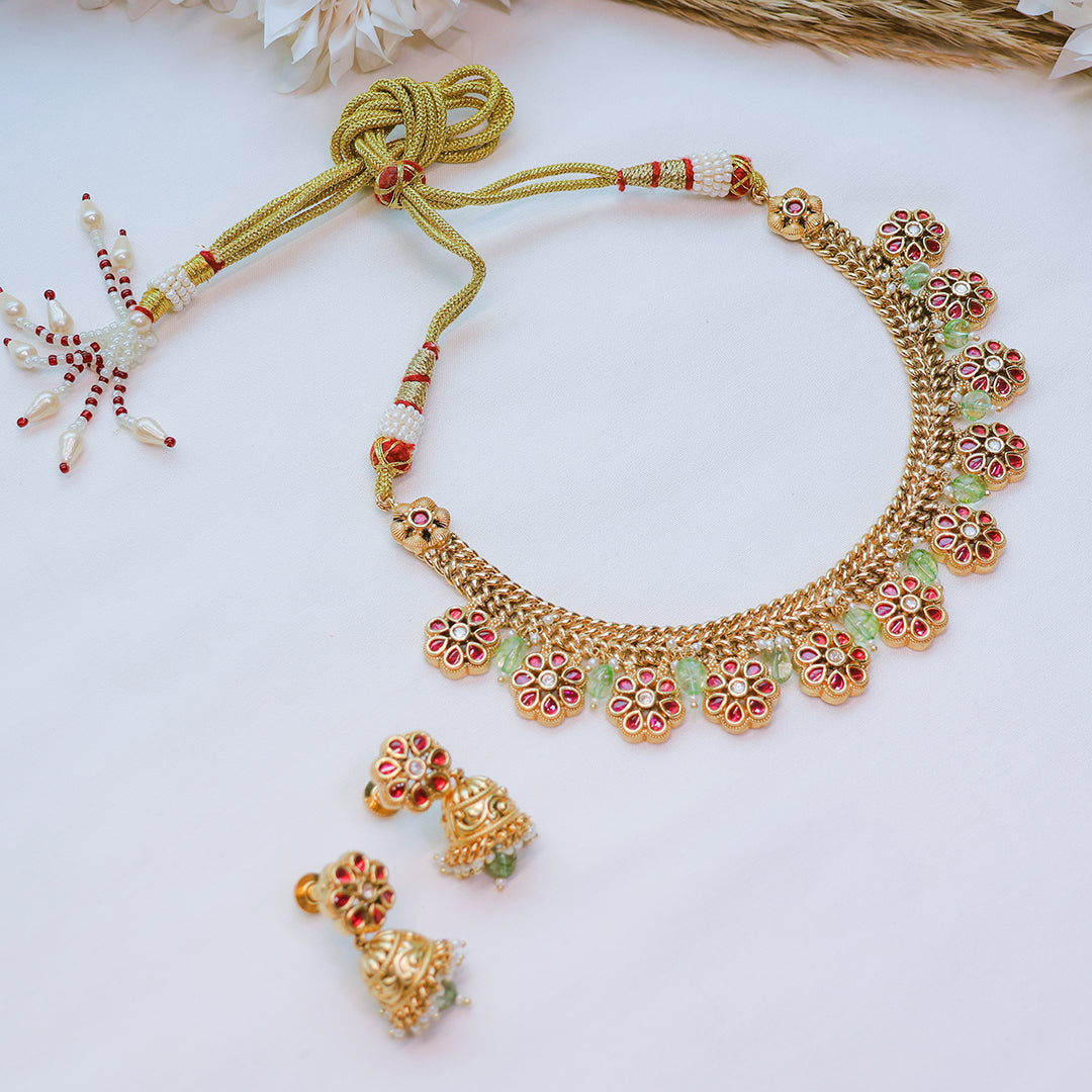 Gold necklace with floral designs on a white background