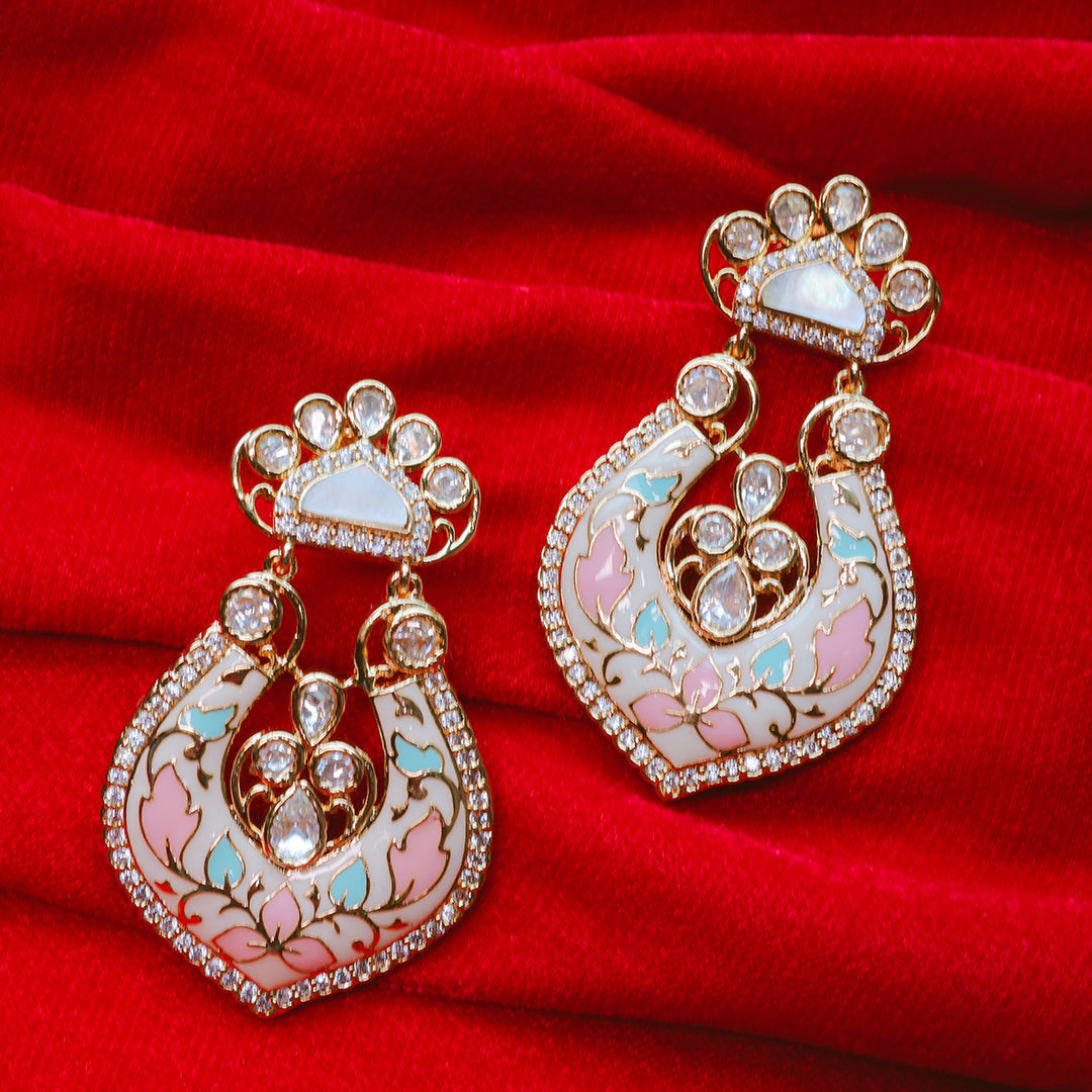 Ornate earrings with gemstones on a red fabric background