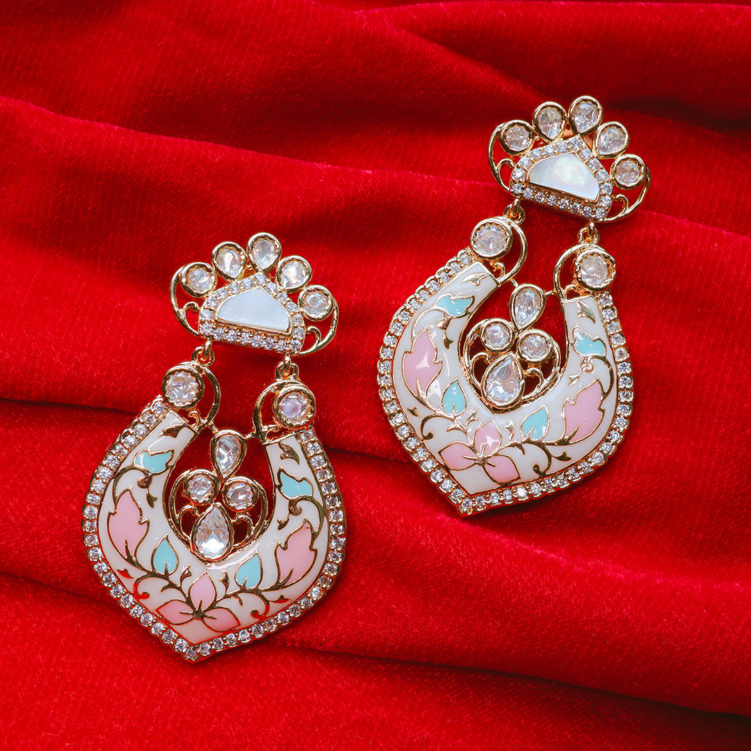 Ornate earrings with gemstones on a red fabric background