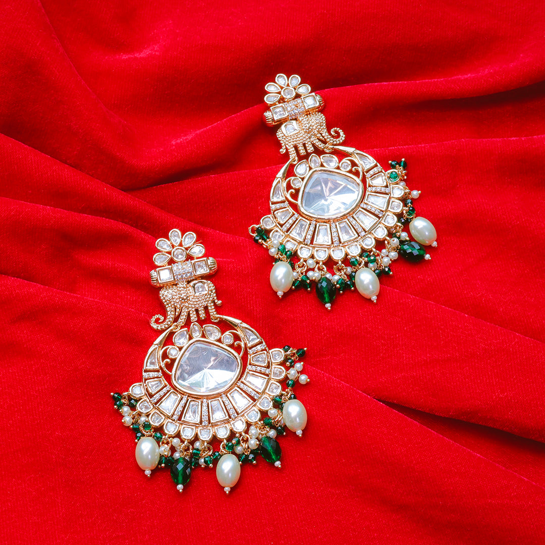 Ornate earrings with gemstones and pearls on a red fabric background