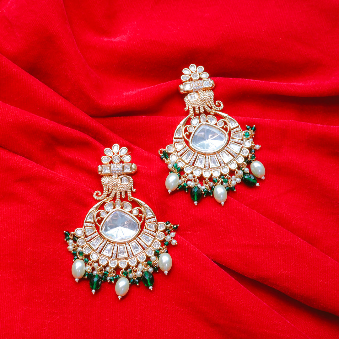 Ornate earrings with gemstones on a red fabric background
