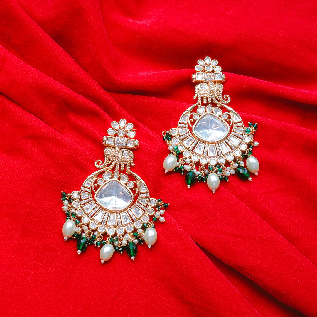 Ornate earrings with gemstones on a red fabric background