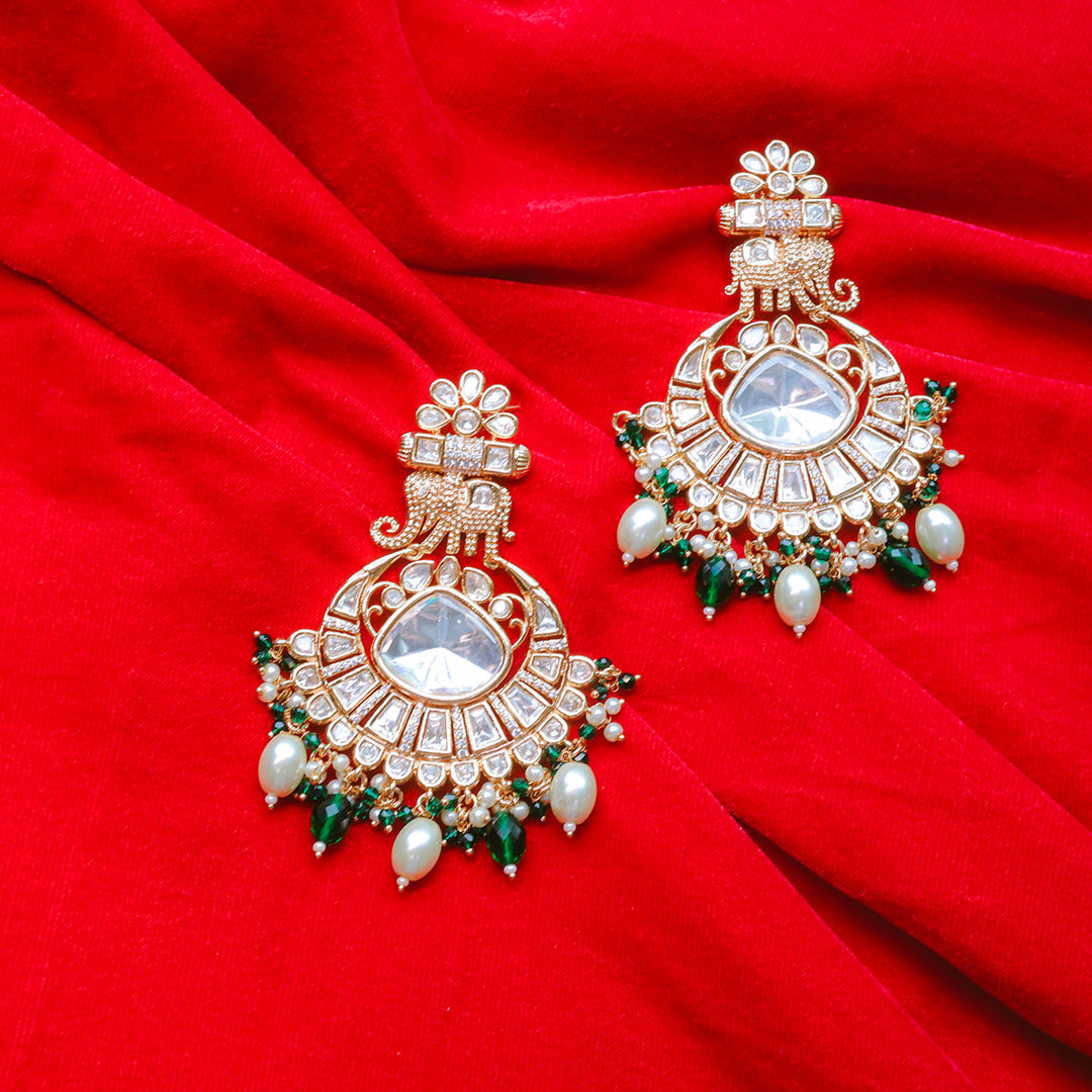 Ornate earrings with gemstones on a red fabric background