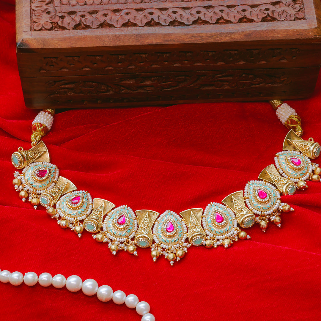 Decorative gold necklace with pink stones on a red fabric background