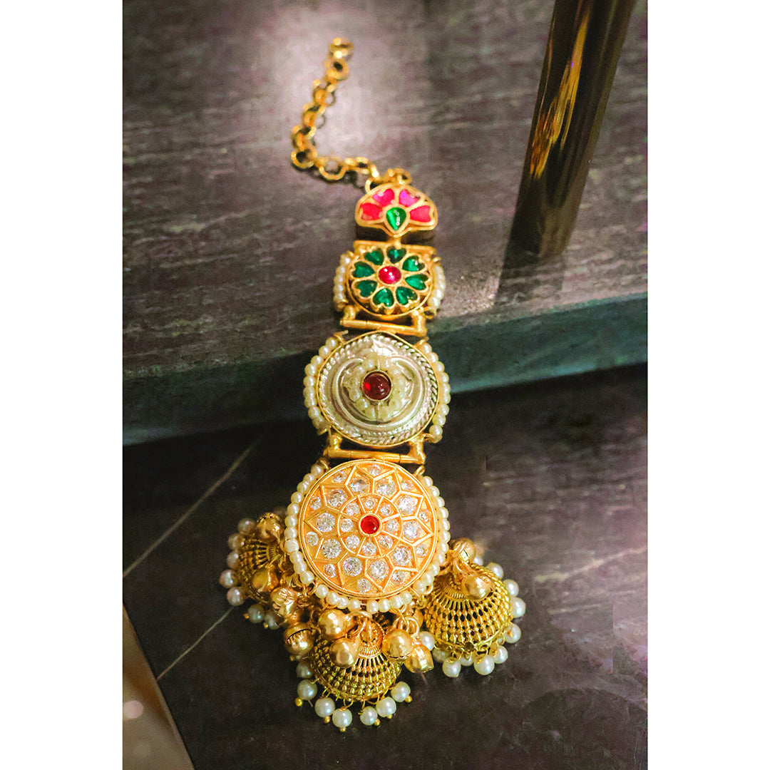 Gold necklace with intricate designs on a dark surface