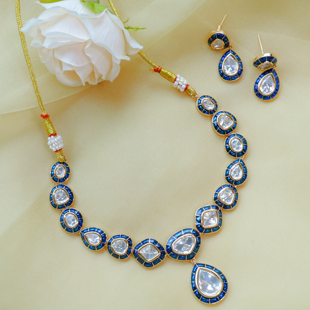 Jewelry set with necklace, earrings, and a white flower on a light background