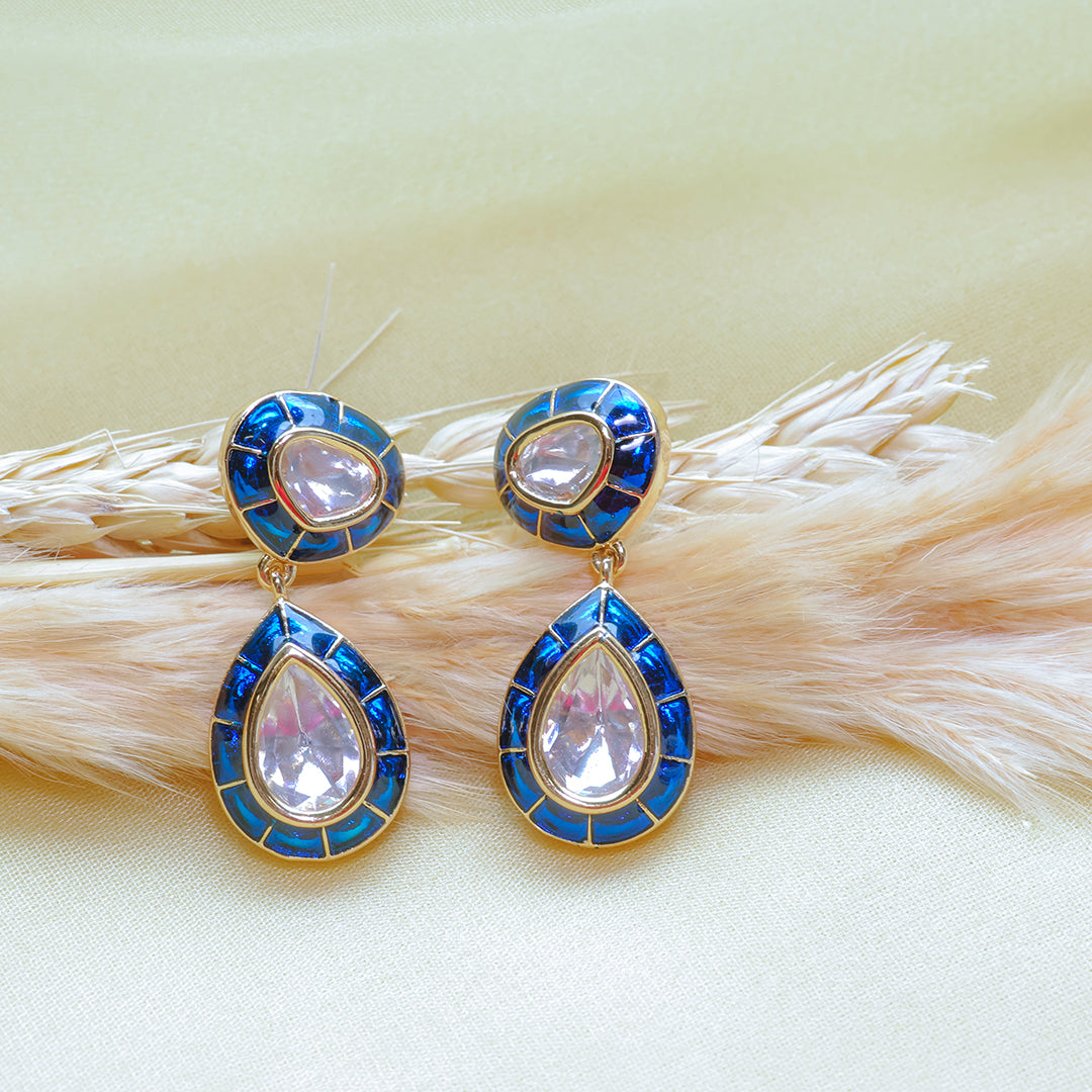 Teardrop-shaped earrings with blue and gold accents on a light background