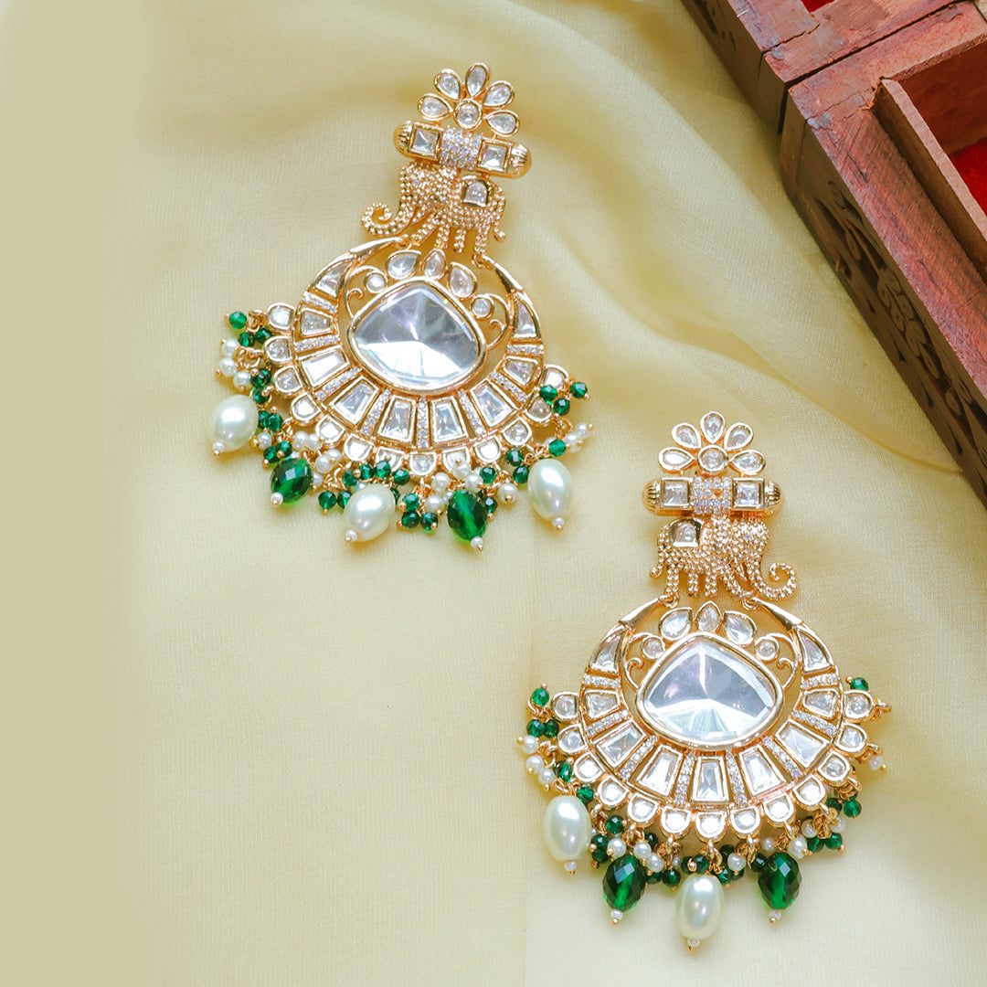 Ornate gold and green jewelry pieces on a beige background