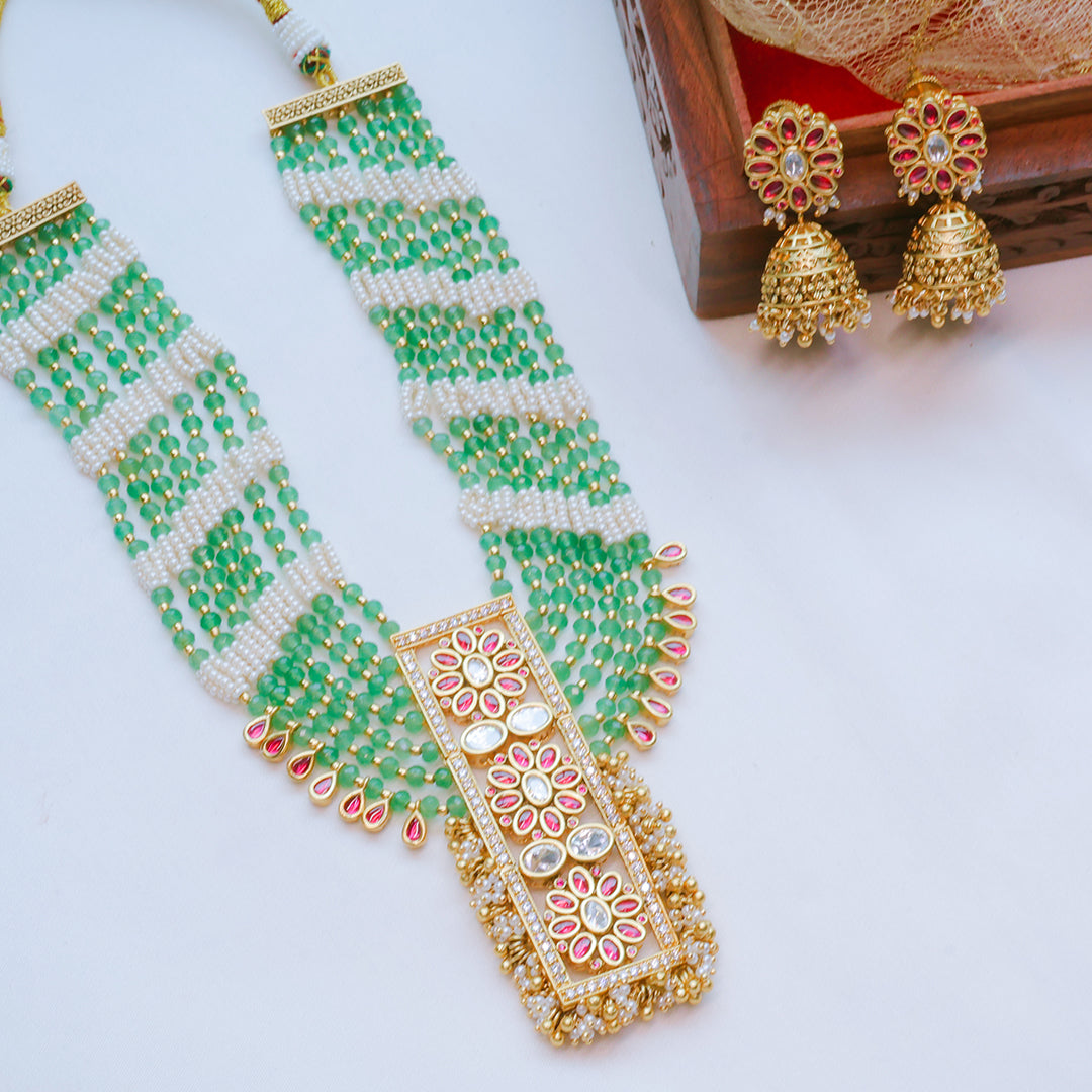 Green and gold beaded necklace with matching earrings on a white background