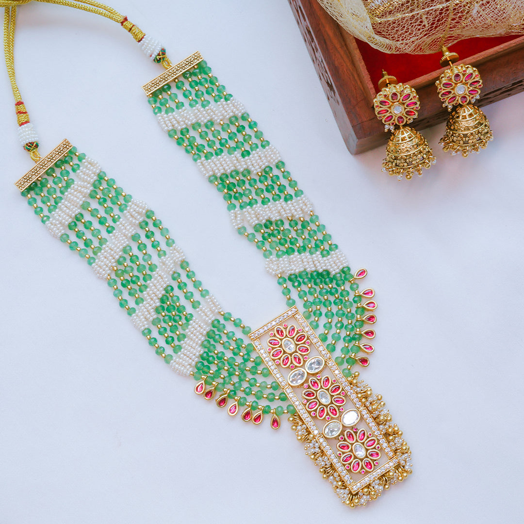 Green and gold beaded necklace with matching earrings on a white background