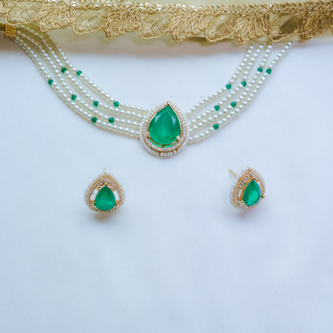 Jewelry set with green teardrop pendants on a white background