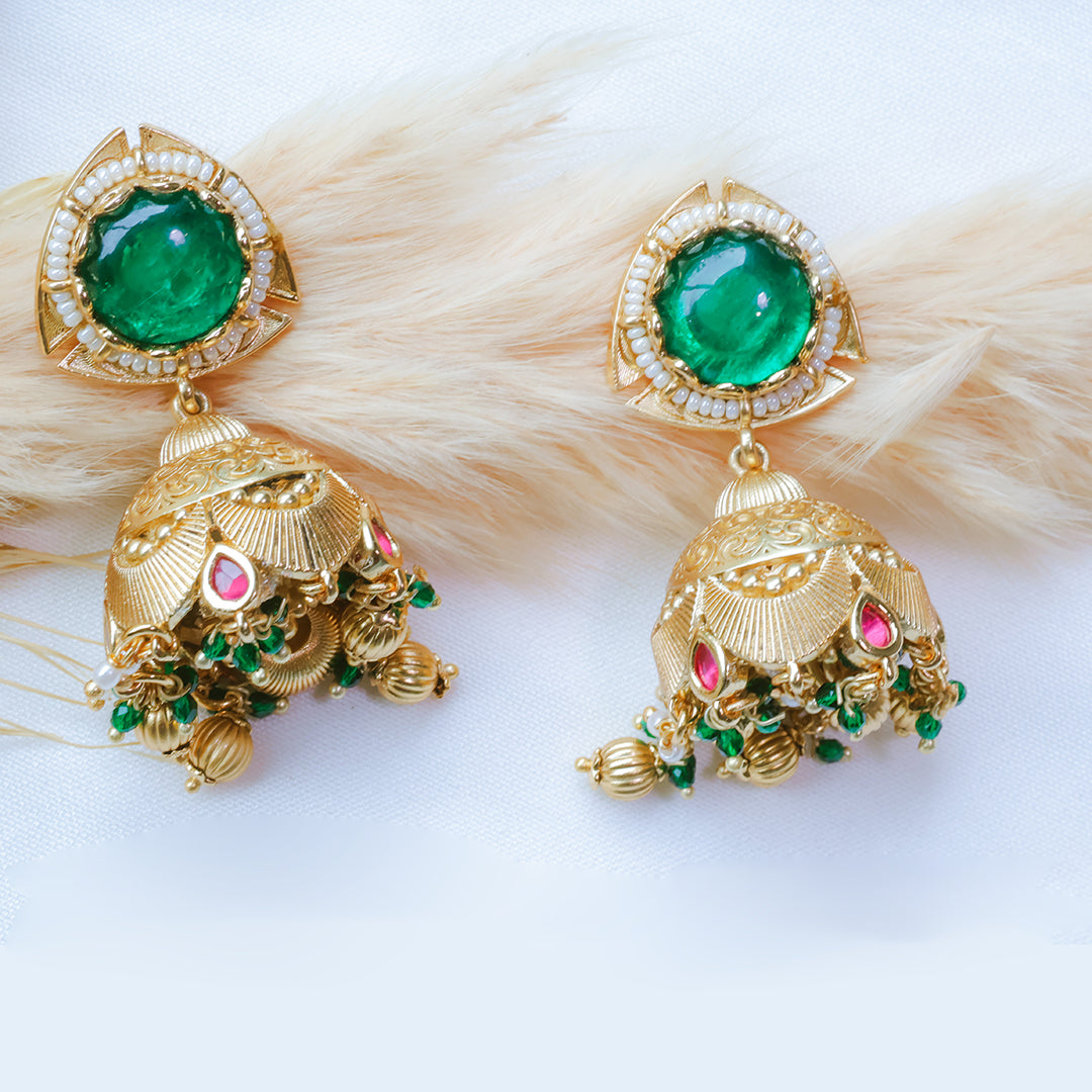Gold earrings with green and pink stones on a white background