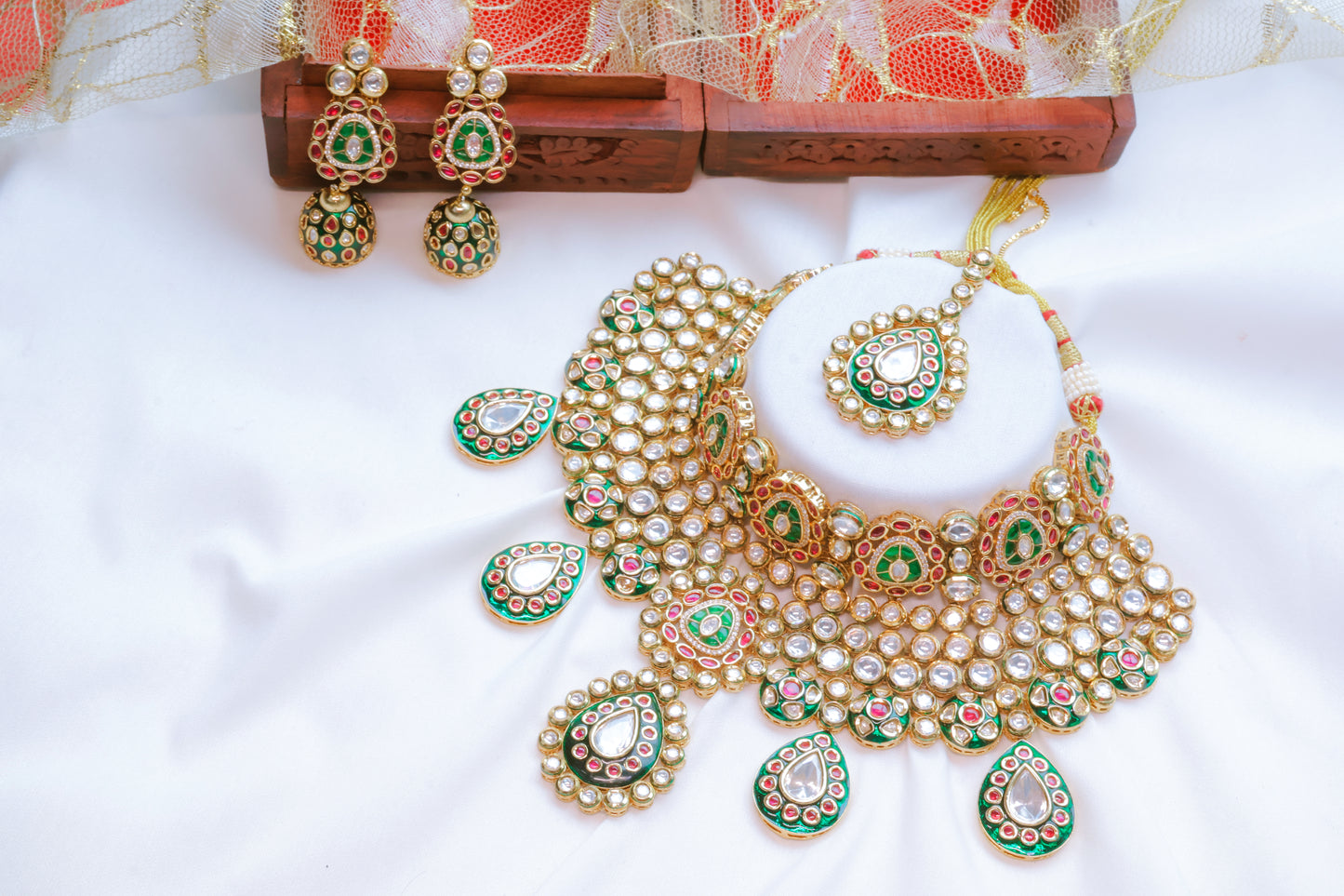 Ornate gold and green jewelry set with earrings on a white background