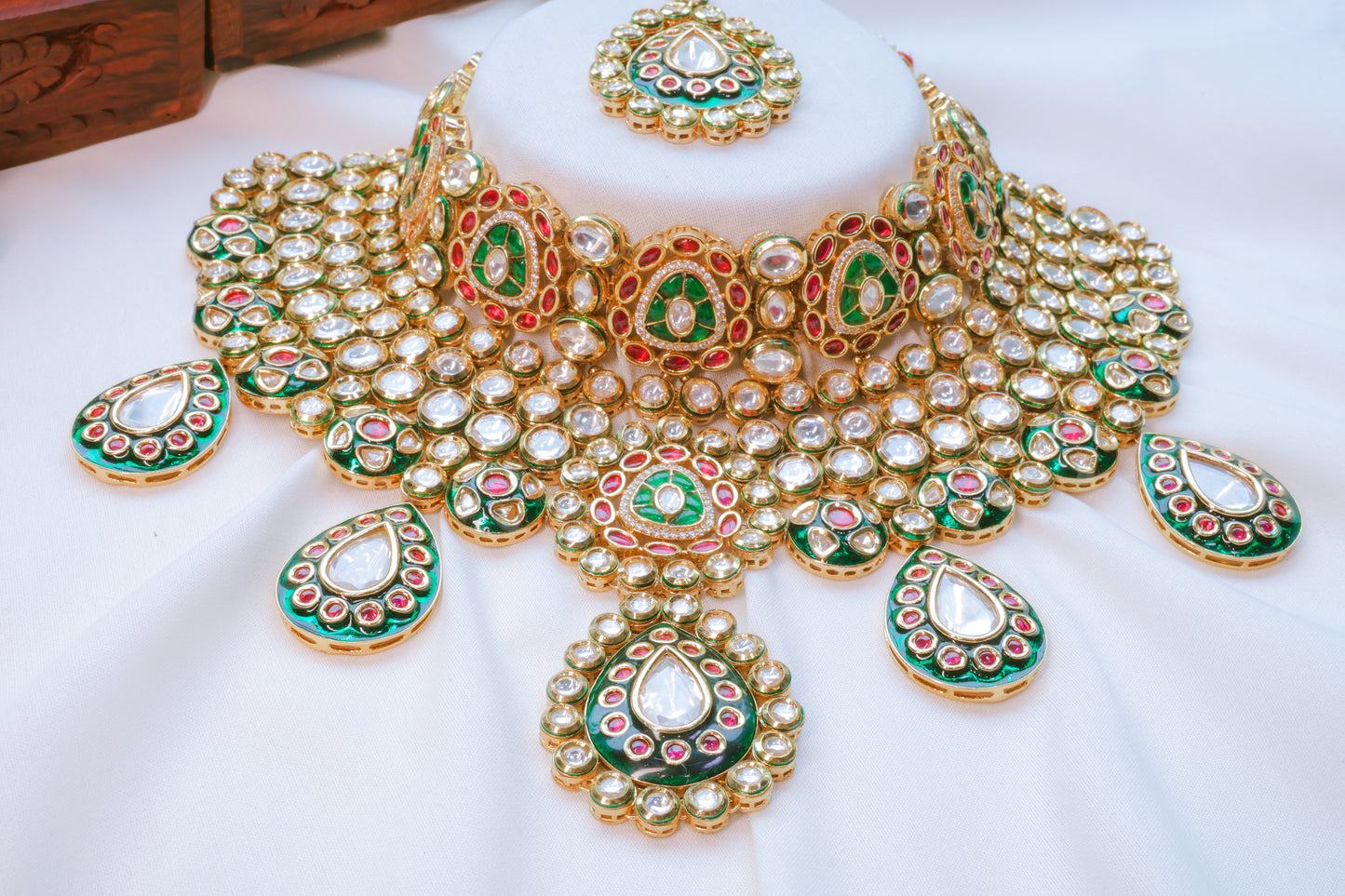 Ornate gold and green jewelry set on a white background