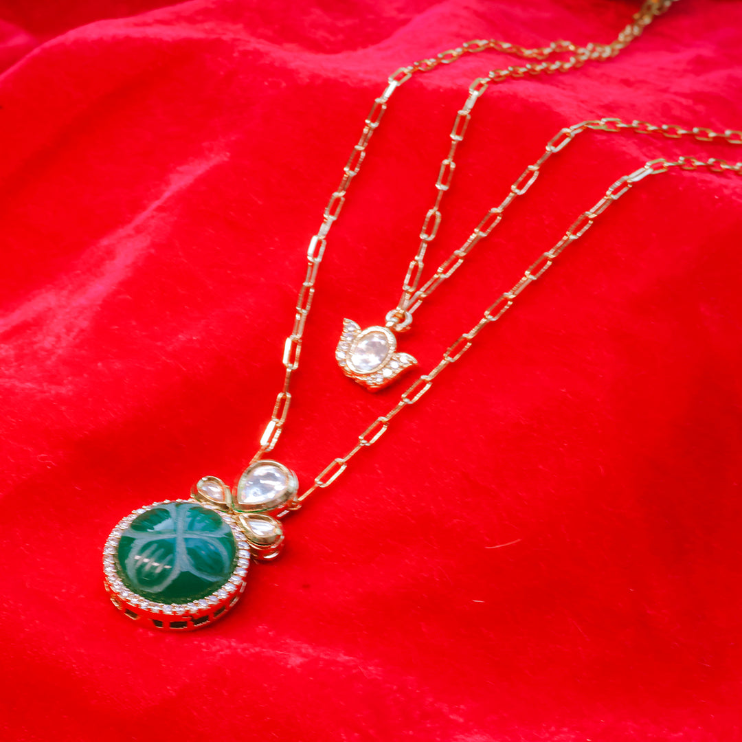 Gold necklace with green pendant on a red fabric background