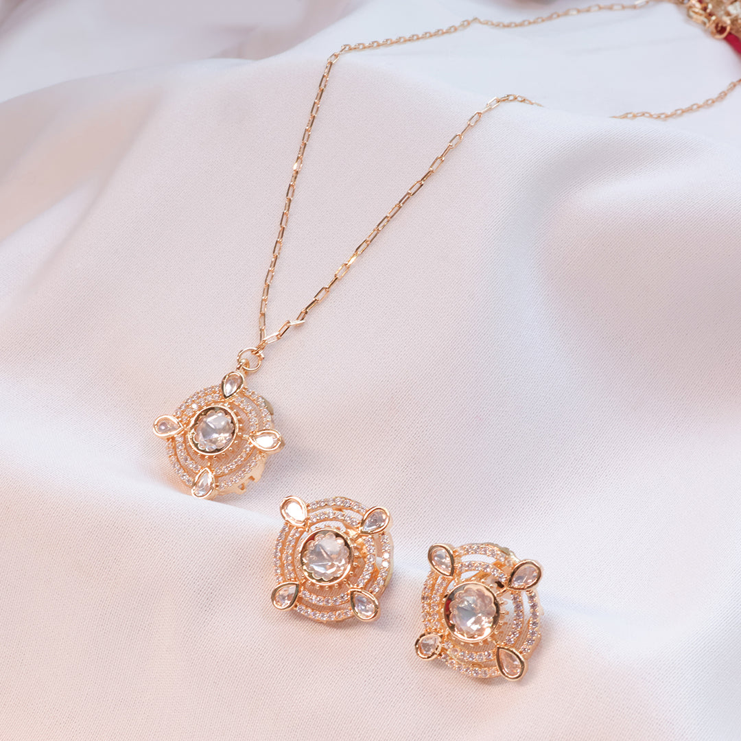 Rose gold necklace and earrings set on a white background