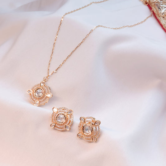 Rose gold necklace and earrings set on a soft white background