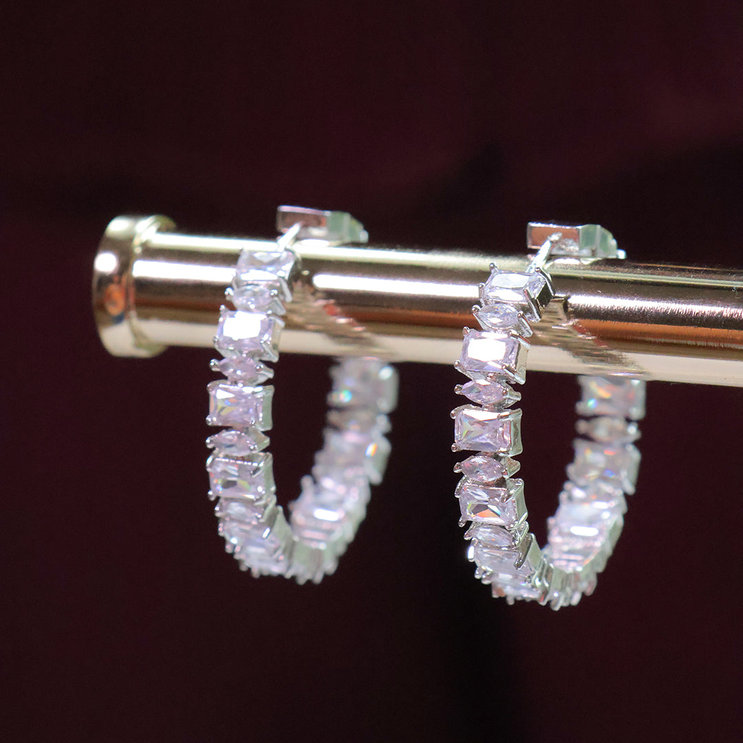 Diamond hoop earrings on a dark background