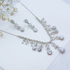 Silver jewelry set with necklace and earrings on a light background
