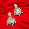Ornate earrings with gemstones and pearls on a red fabric background