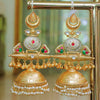 Ornate gold earrings with pearls and gemstones on a stand.