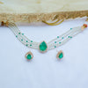 Jewelry set with necklace and earrings featuring green teardrop pendants on a white background.