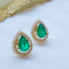 Gold earrings with green gemstones on a white background