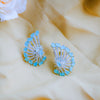 Pair of blue and silver earrings on a beige fabric background