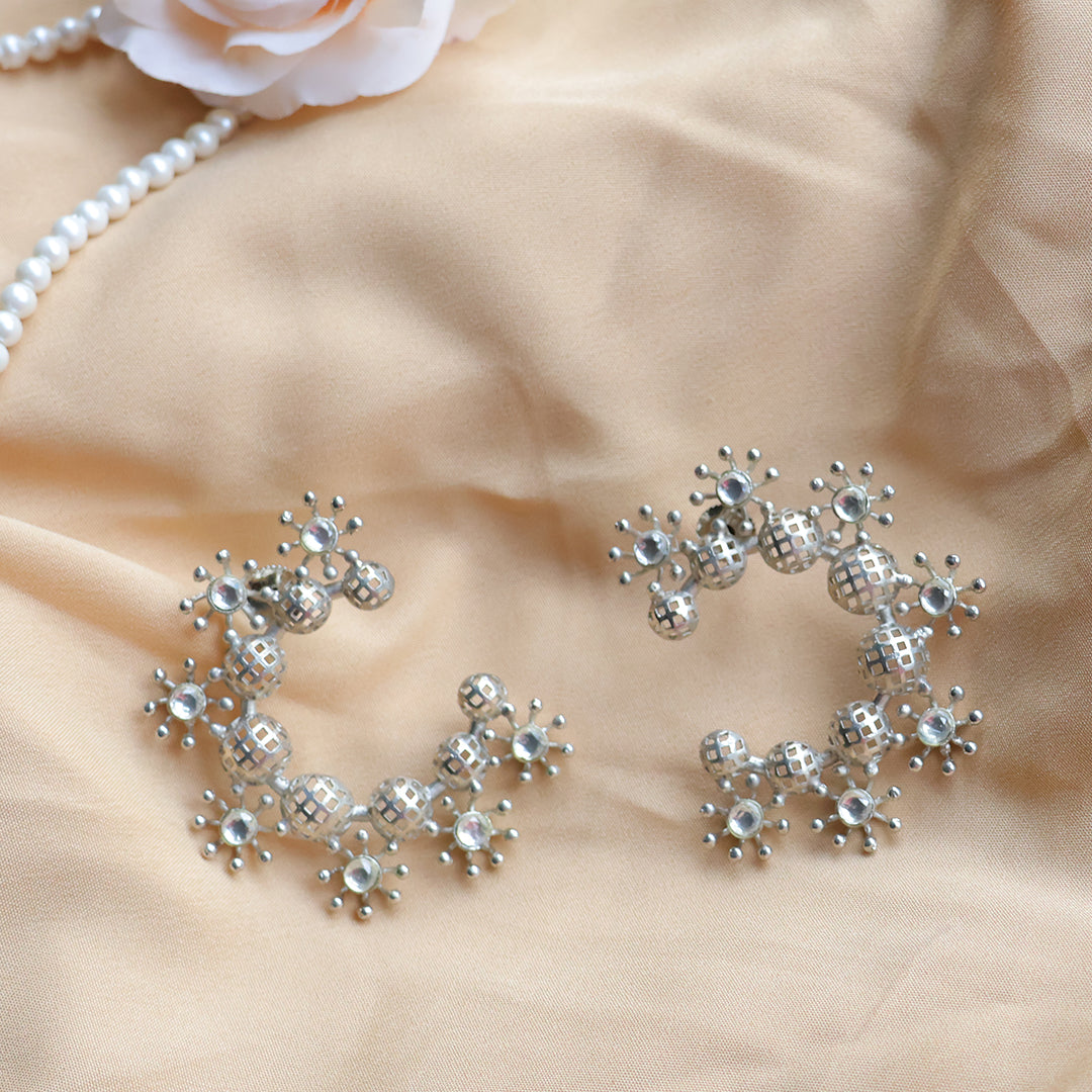 Silver jewelry set on a beige fabric background