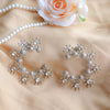 Silver jewelry set with necklace and earrings on a beige fabric background